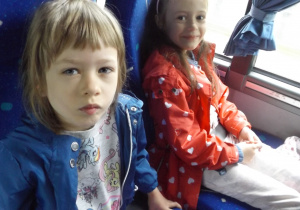 dwie dziewczynki siedzą obok siebie w autokarze